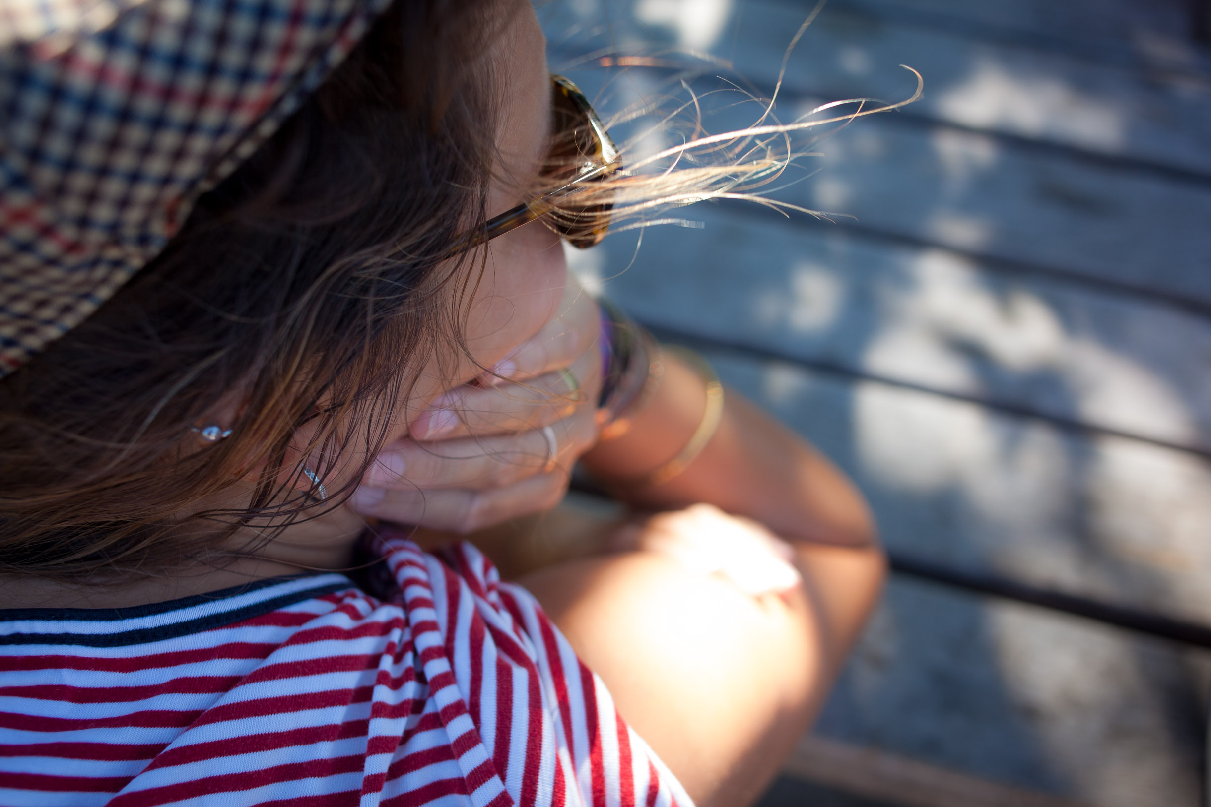 Vue par-dessus l'épaule d'une femme appuyée sur une table, cheveux au vent, série Moment in Time